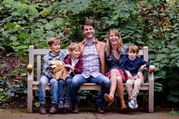 Paradise Teak Family sitting on a teak outdoor bench with greenery in background Paradise Teak Bay Area California
