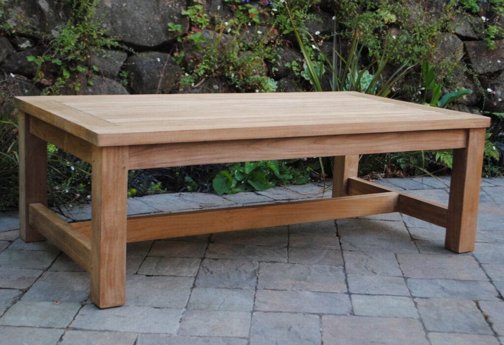 Large Rectangle teak Coffee Table on a patio with rocks and greenery in background Paradise Teak Bay Area California
